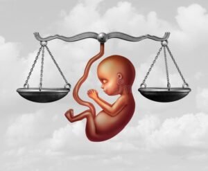 bilancia della giustizia con feto e mani