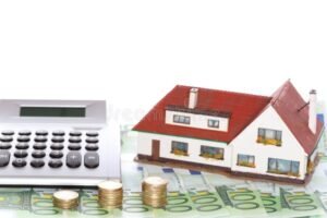 casa con calcolatrice e simboli finanziari
