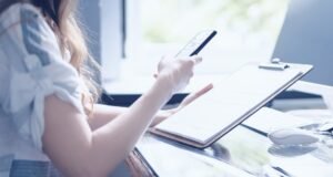 persona al telefono con documenti accanto