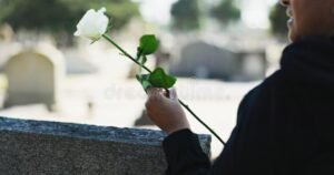 persone che tengono un fiore commemorativo